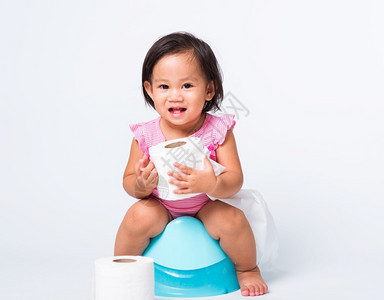 亚洲可爱的小婴儿女教育培训练他们坐在蓝室锅或便壶上手持卫生纸卷在白色背景上孤立的演播室拍摄Wc厕所概念图片