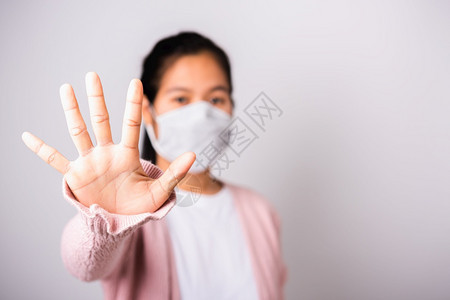 身穿外科保护的亚洲妇女面对冠状的罩卫生她举起手停牌工作室用复制空间COVID19或冠状概念在白色背景上单独拍摄带有复制空间COV图片