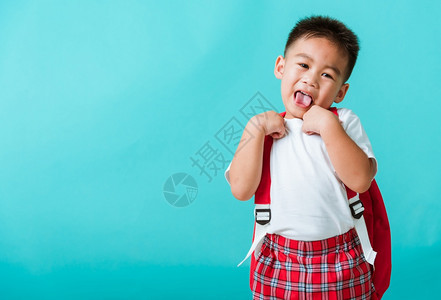 穿着制服笑孤立的蓝背景亚洲可爱男孩图片