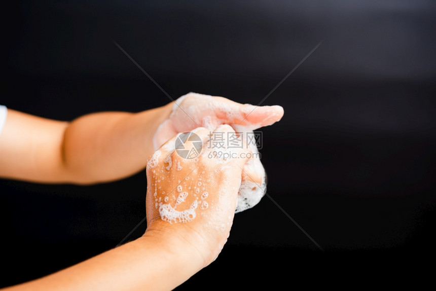 亚洲青年妇女用肥皂洗手时有泡沫卫生预防COVID19或冠状保护概念以黑色背景隔离图片