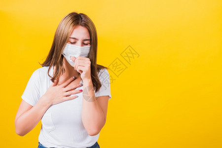亚洲肖像美丽可爱的年轻女站着穿T恤衫咳嗽面罩防COVID流行或空气污染隔离图片