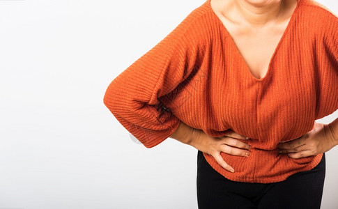 她生病的亚裔妇女有胃痛肚子手握在腹部身体的一分女有痛苦的胃腹部发炎或慢胃工作室被孤立在白色背景上图片