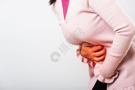 亚裔患病女有胃痛手握在腹部身体的一分女有痛苦的胃她有问题疾病是便或结肠图片