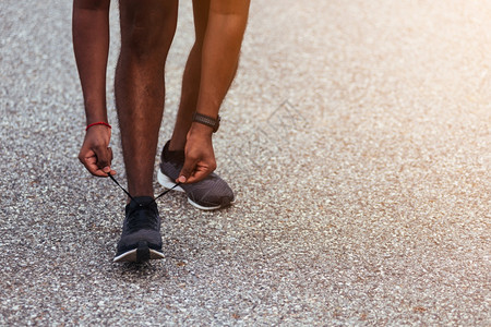 近亚洲运动赛跑选手黑人站着尝试鞋带跑准备慢和在户外街头健康公园跑运动锻炼概念图片