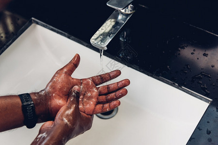 使用肥皂和水浸入槽用浴皂和冲洗黑人手防止爆发日冕卫生以阻止传播清洁COVID19检疫卫生概念图片