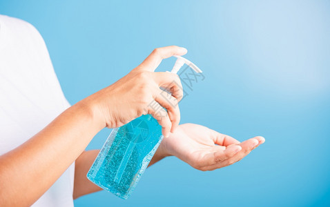 亚洲青年妇女在洗手清洁卫生预防COVID19或蓝底隔离的冠状保护概念图片