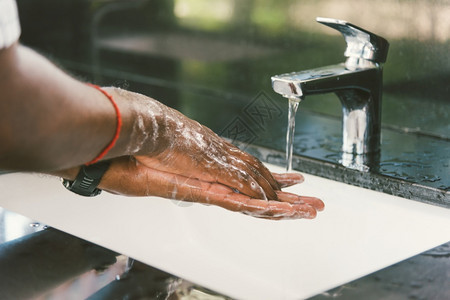 使用肥皂和水浸入槽用浴皂和冲洗黑人手防止爆发日冕卫生以阻止传播清洁COVID19检疫卫生概念图片