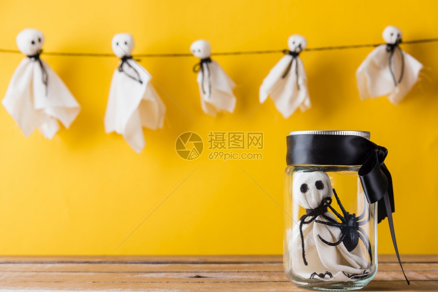 可爱万圣节装饰晚会可爱的白色鬼魂手工艺挂在背景的可怕脸蛋只有一个婴儿鬼在玻璃罐里孤立的黄色 快乐节日diy手工艺概念高清图片下载 正版图片 摄图网