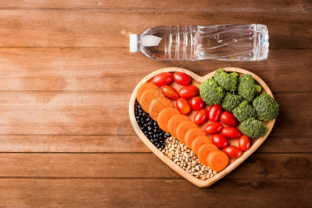 心板木carrotBrocoli番茄和木制桌上塑料水瓶中新鲜有机果和蔬菜carrot番茄以及木制桌上塑料水瓶的顶端视图健康生活方图片
