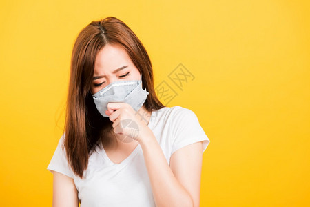 亚洲快乐肖像美丽可爱的年轻少女站着穿T恤衫咳嗽面罩防流行或空气污染图片