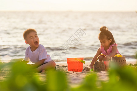 两个孩子在户外热带海滩玩沙子图片