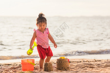 两个孩子在户外热带海滩玩沙子图片