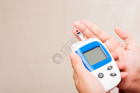 测量葡萄糖试水平用血压计检查手指的妇女图片