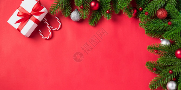 圣诞假日背景配有礼品箱装饰构成FirFir绿色fir树枝和红桌背景的Xma装饰礼品盒新年快乐概念图片