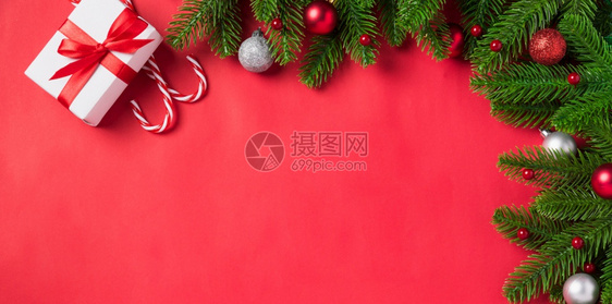 圣诞假日背景配有礼品箱装饰构成FirFir绿色fir树枝和红桌背景的Xma装饰礼品盒新年快乐概念图片