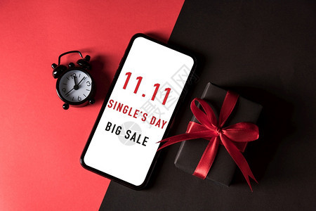 1销售购物概念黑纸弓丝带和移动智能手机包裹的礼品盒最佳视图有1个购物日在红色和黑暗背景的白色屏幕上大销售文本图片
