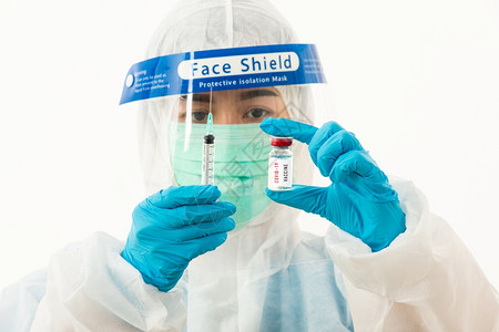 身穿个人防护设备制服身着面罩防护和塑料面罩的女医学科家为白种隔离的科罗纳爆发COVID19疫苗和注射器检而持有防护罩图片