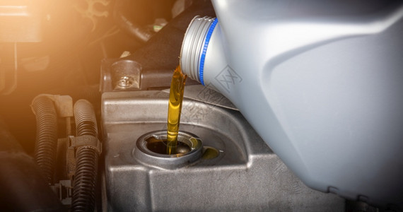 在维修服务站理汽车加油和从瓶倒灌换润滑油的机械能源燃料汽车概念背景图片