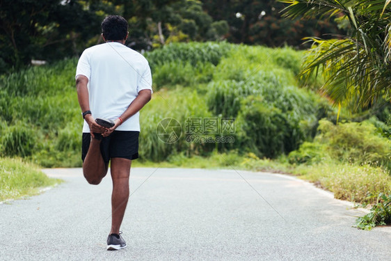特写亚洲年轻运动员运动跑步者黑人男子戴手表抬脚伸展腿部和膝盖在户外街道健康公园跑步前锻炼前的健康锻炼概念图片