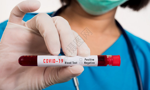 穿蓝制服护士在实验室内戴面具持有试管样本并戴面具在化验室内新冠血样分析白底孤立的药物COVID19流行病爆发概念图片