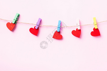 情人节快乐的概念红心形情人节装饰上挂着木片剪贴的红心形情人节装饰在粉红背景与复制空间隔离的绳索上挂着爱图片