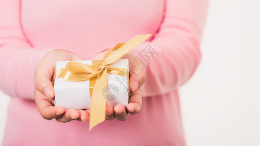情人节女美手拿着小礼物盒赠送带丝圣诞新年生日假背景概念的包装纸图片
