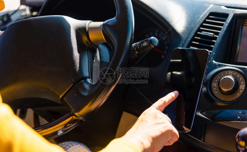 亚裔女在汽车内手机智能空白屏幕上使用触摸早上在高速公路驾驶汽车时图片
