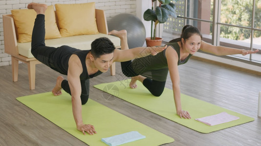 一对家庭夫妇在家中练瑜伽锻炼身体图片