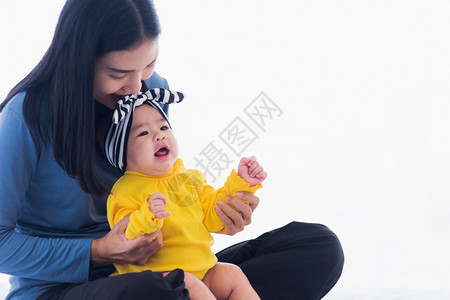 美丽的年轻亚洲母亲肖像在家里和他刚出生的小宝一起玩耍和微笑父母妈和小孩在卧室放松家人一起玩乐图片