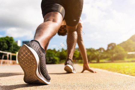 亚洲青年运动员跑亚洲黑人者积极准备在户外运动场上开始训练以便向前迈出一步健康锻炼在脚鞋上闭合图片