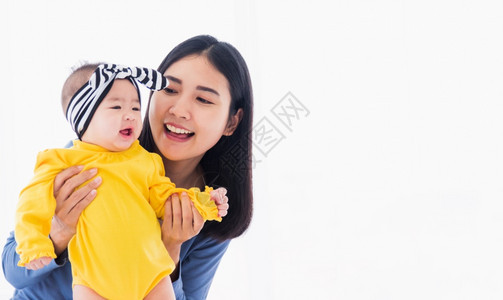 美丽的年轻亚洲母亲肖像在家里和他刚出生的小宝一起玩耍和微笑父母妈和小孩在卧室放松家人一起玩乐图片