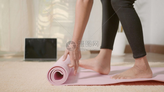 亚洲青年女子在运动前滚健身瑜伽粉色垫子女在起居室家工作图片