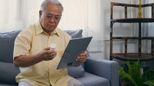 亚洲老年病人用数字平板电脑给医生录像话询图片
