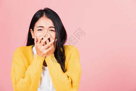 亚洲肖像美丽可爱的年轻女站立惊异吓的嘴盖着手掌的套看着摄影机棚拍图片