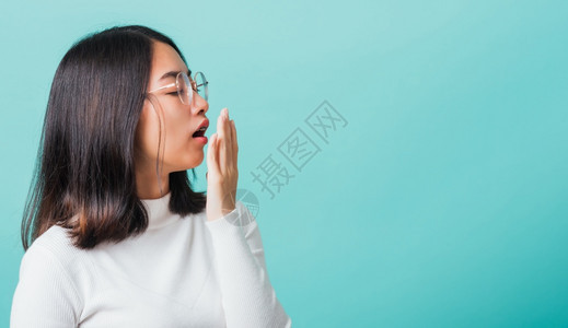 年轻美丽的亚洲女人睡着用棕榈张开嘴用棕榈开摄影棚拍到蓝色背景图片