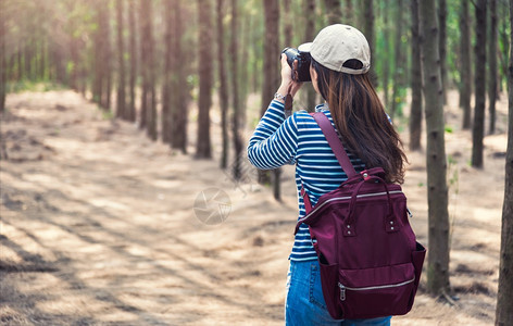 年轻女生活方式摄影师在森林自然中旅行携带背负腹部复制空间图片
