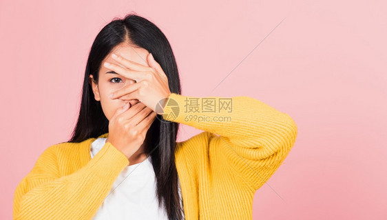 亚洲肖像美丽的年轻女心情沮丧的坏用双手遮面一只眼睛对着她的手指工作室图片