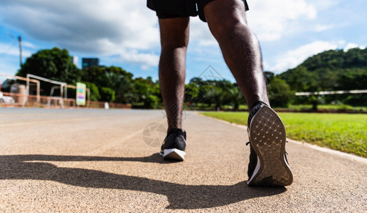 亚洲青年运动员跑步的黑人佩戴主动的脚准备在跑步车线路的户外训练以便向前一步健康锻炼补鞋图片