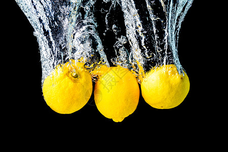 柠檬喷入水中沉黑底美味健康的食物沉入黑底图片