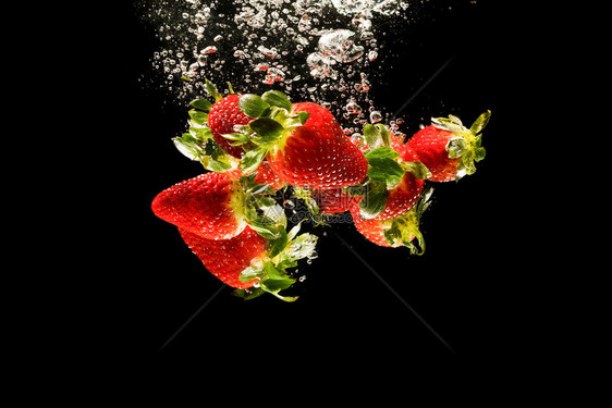 草莓掉入水中在造成周围的泡沫健康食品概念黑底草莓掉入水中在造成泡沫健康食品概念图片