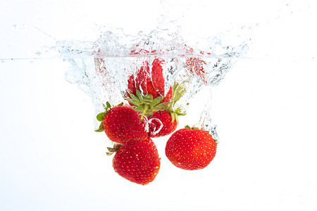 草莓掉入水中周围产生泡沫健康的食品概念水下喷洒摄影草莓掉入水中周围产生泡沫健康的食品概念图片