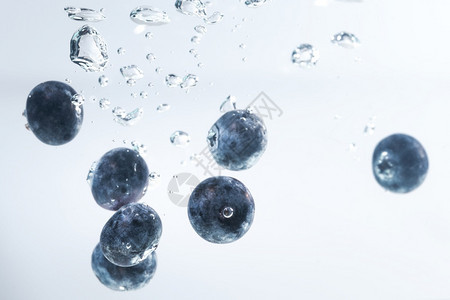 有机蓝莓沉入水中空气泡在白色背景上有机蓝莓沉入水中空气泡在图片