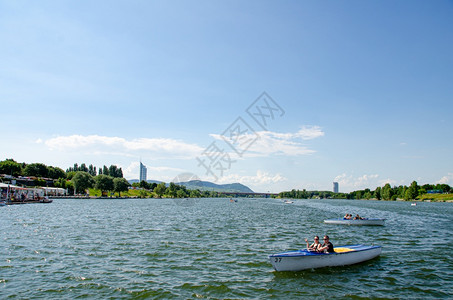 奥地利维也纳2013年6月日维也纳新迪南贝丹岛附近的娱乐区人们租船游过河流维也纳新迪南贝娱乐区图片