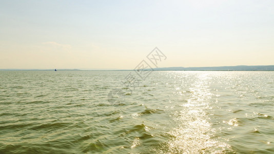 奥地利内西德列尔斯湖上的Catamaran船日落前清空平静的水与日落后空间相仿奥地利内西德列尔斯湖上的Catamaran船图片