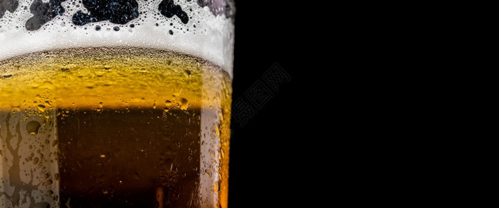 玻璃杯啤酒和黑背景检查的泡沫复制右侧的空间玻璃杯啤酒和黑背景检查的泡沫图片