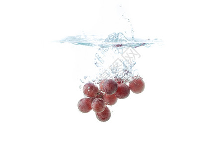 孤立的红葡萄喷洒和沉在水中白色背景空气泡图片