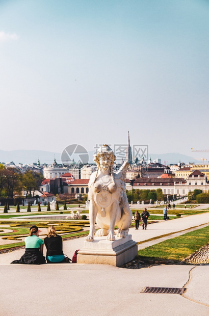 2013年4月日维也纳奥地利前景中的妇女狮身人面像背景中的维也纳城市和行走途中的游客图片
