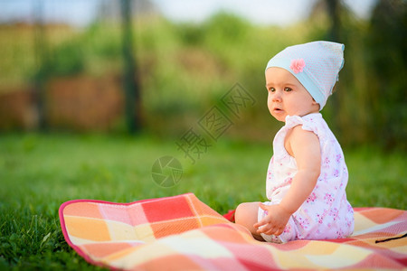 坐在花园草坪上的女婴图片