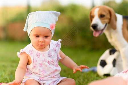 9个月大的婴儿女独自坐在花园草地上毯子丰富多彩图片
