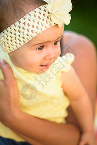 穿着黄带和装的可爱女婴阳光夏日户外活动母亲概念美丽的年轻母亲带着可爱女婴穿黄色带和着装图片